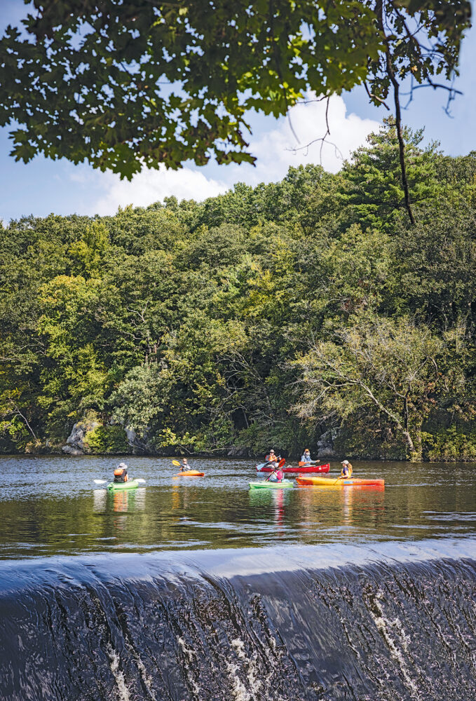 Kayakers on the Blackstone River come  up to a dam they will have to go around.